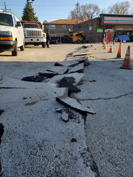 Broken blacktop in a 7 Eleven gas station lot