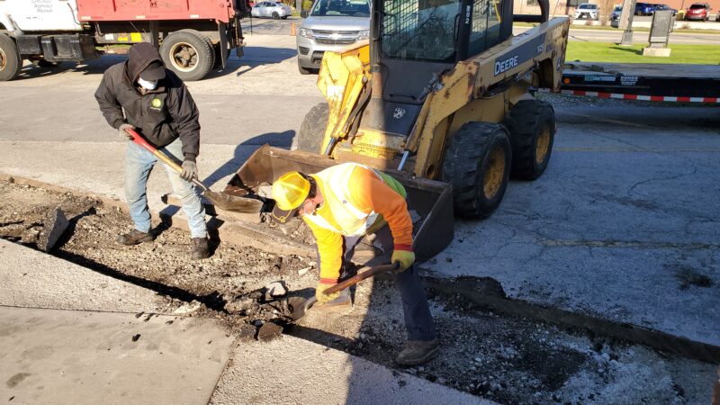 Construction crew removing blacktop debris.