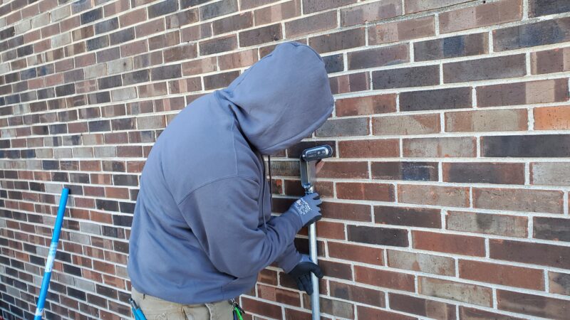 Electrician connecting pipes to a building.