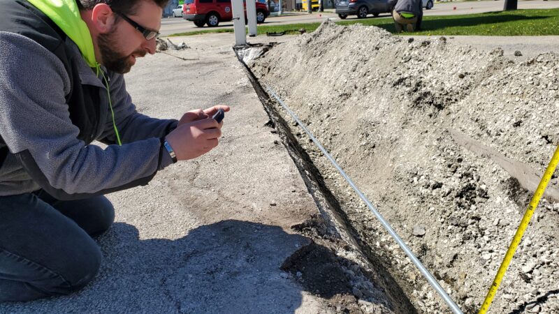 Construction Manager checking the depth of a trench.