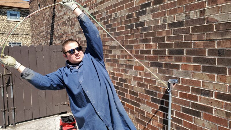 Electrician pulling wires through a pipe.