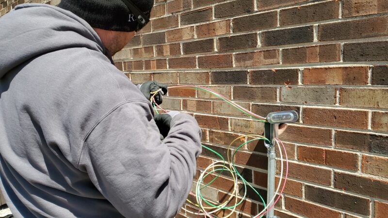 electrician running wires into a building.